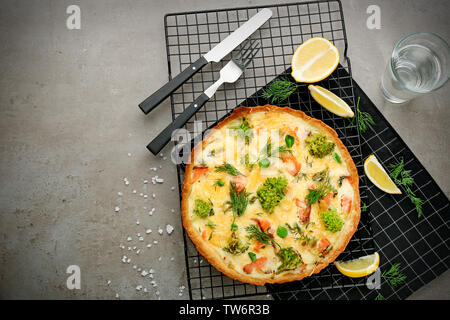 Tasty salmon quiche on cooling rack Stock Photo