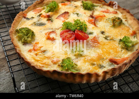 Tasty salmon quiche on cooling rack Stock Photo