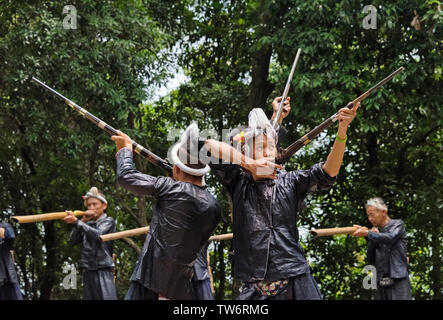 Basha Miao men in traditional clothing firing guns, Guizhou Province, China Stock Photo