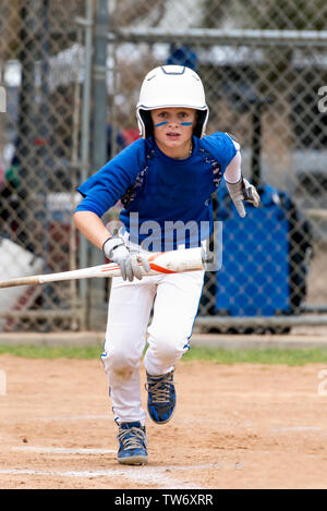 Child baseball player focused ready to bat. Kid holding a baseball