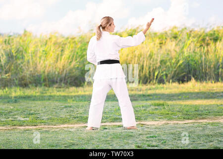 Young woman practicing karate outdoors Stock Photo