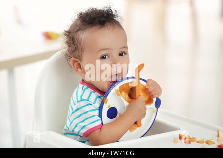 https://l450v.alamy.com/450v/tw71cg/cute-baby-with-spoon-and-plate-sitting-on-chair-in-kitchen-tw71cg.jpg