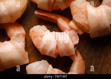 Bacon-wrapped shrimps on wooden background, closeup Stock Photo