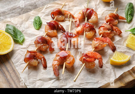 Skewered shrimps wrapped in bacon on board Stock Photo