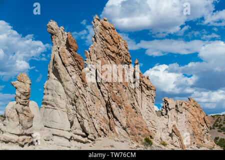 Unusual, craggy rock formations and rugged pinnacles under a beautiful blue sky with white puffy clouds - Plaza Blanca near Abiquiu, New Mexico Stock Photo
