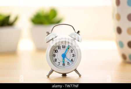 Alarm clock on table indoors. Morning routine concept Stock Photo
