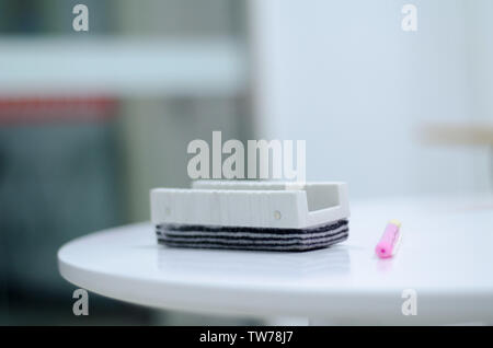 A whiteboard, brush, eraser and a red pen on the desk in the classroom. Stock Photo