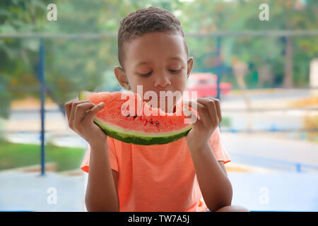 Cute African American boy eating watermelon at home Stock Photo