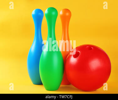 Bright bowling pins and ball on color background Stock Photo