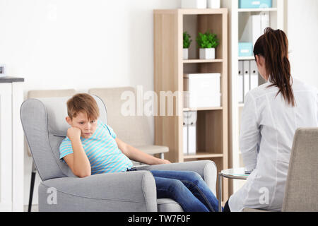 Female psychologist working with overweight boy in office Stock Photo