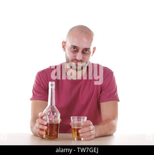 Drunk man sitting at table with whiskey against white background. Alcoholism concept Stock Photo