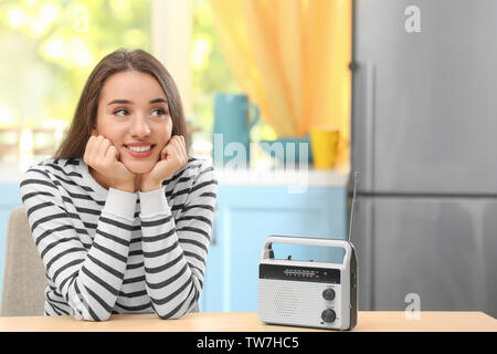 Young woman listening to radio in kitchen Stock Photo - Alamy