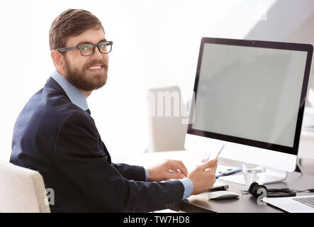 Manager using mobile phone while working in office Stock Photo