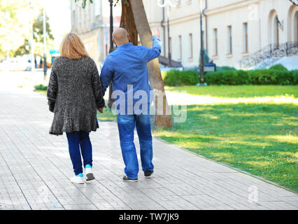 Overweight couple walking in park Stock Photo