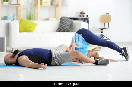 Overweight couple doing exercises at home Stock Photo