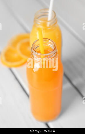 Bottles with fruit juices on table Stock Photo