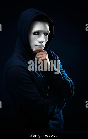 Hacker in mask on dark background Stock Photo