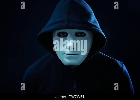 Hacker in mask on dark background Stock Photo