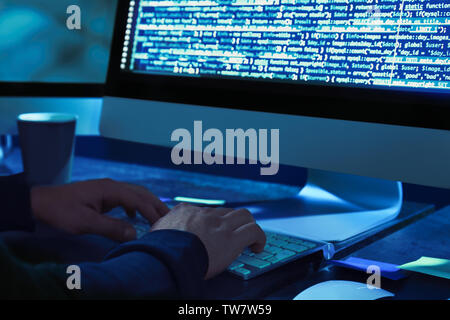 Hacker using computer in dark room Stock Photo