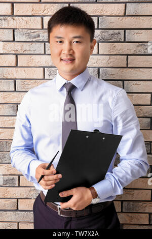 Young manager on brick wall background Stock Photo