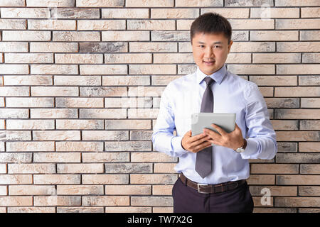 Young manager on brick wall background Stock Photo