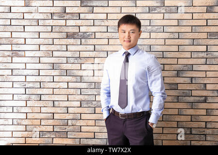 Young manager on brick wall background Stock Photo