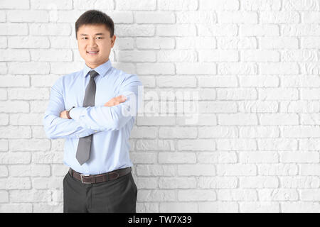 Young manager on brick wall background Stock Photo
