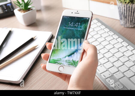 KIEV, UKRAINE - OCTOBER 09, 2017: Woman with Rose Gold iPhone 6S at table in office Stock Photo