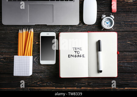 Composition with phrase "Time to Engage" written in notebook on wooden background Stock Photo