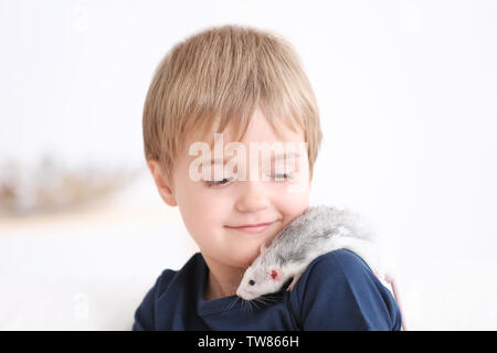 Little boy with cute pet rat on sofa indoors Stock Photo