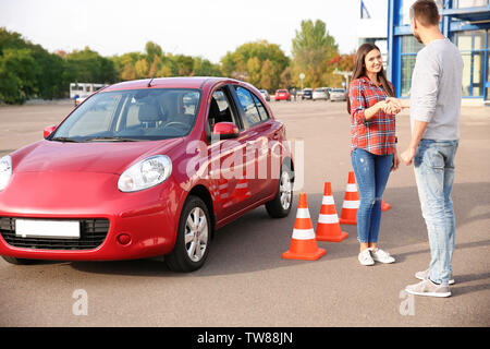 Instructor and young woman passed driving license exam Stock Photo