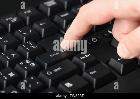 Woman pressing "Enter" button on computer keyboard, closeup Stock Photo