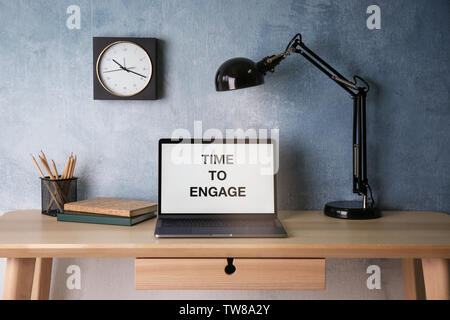 Text TIME TO ENGAGE on screen of laptop on table Stock Photo
