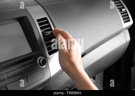 Woman adjusting air conditioner in car, closeup Stock Photo