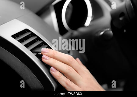 Woman adjusting air conditioner in car, closeup Stock Photo