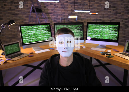 Masked hacker in dark room with computers. Threat of cyber attack Stock ...