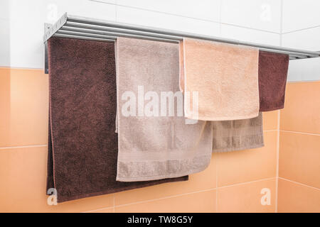 Soft towels drying on rack in bathroom Stock Photo