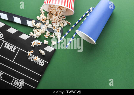 Composition with popcorn and movie clapper on color background Stock Photo