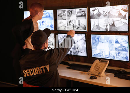 Security guards working in surveillance room Stock Photo