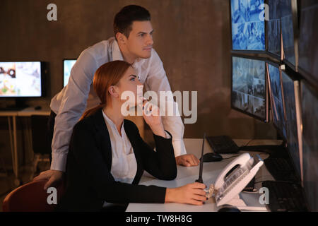 Security guards working in surveillance room Stock Photo