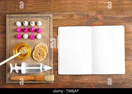 Kitchen utensils with ingredients for pastries and notebook on wooden background Stock Photo
