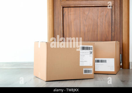 Delivered parcels on floor near front door Stock Photo