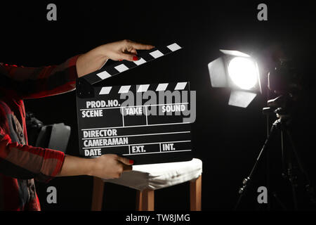 Hands holding a clapper while filming a video movie on TV. A clapper ...