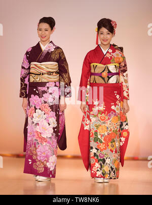 License available at MaximImages.com - Japanese ladies in a beautiful colorful red and purple kimono with floral design at a fashion show in Kyoto