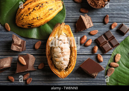 Composition with cocoa pod and products on wooden background, top view Stock Photo