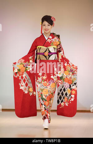 License and prints at MaximImages.com - Young Japanese woman in a beautiful bright red kimono with a colorful floral pattern, golden obi. Japan