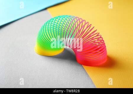 Rainbow slinky on color background Stock Photo