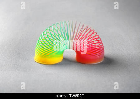 Rainbow slinky on grey background Stock Photo