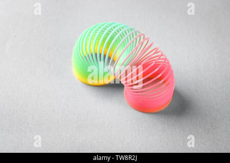 Rainbow slinky on grey background Stock Photo