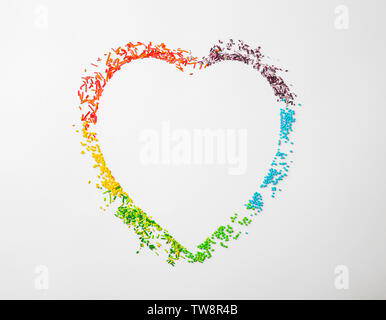 Many rainbow sprinkles in shape of heart on white background Stock Photo